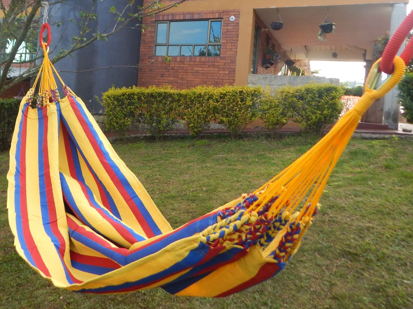 Hamaca Ensueño tricolor colgada en un jardín